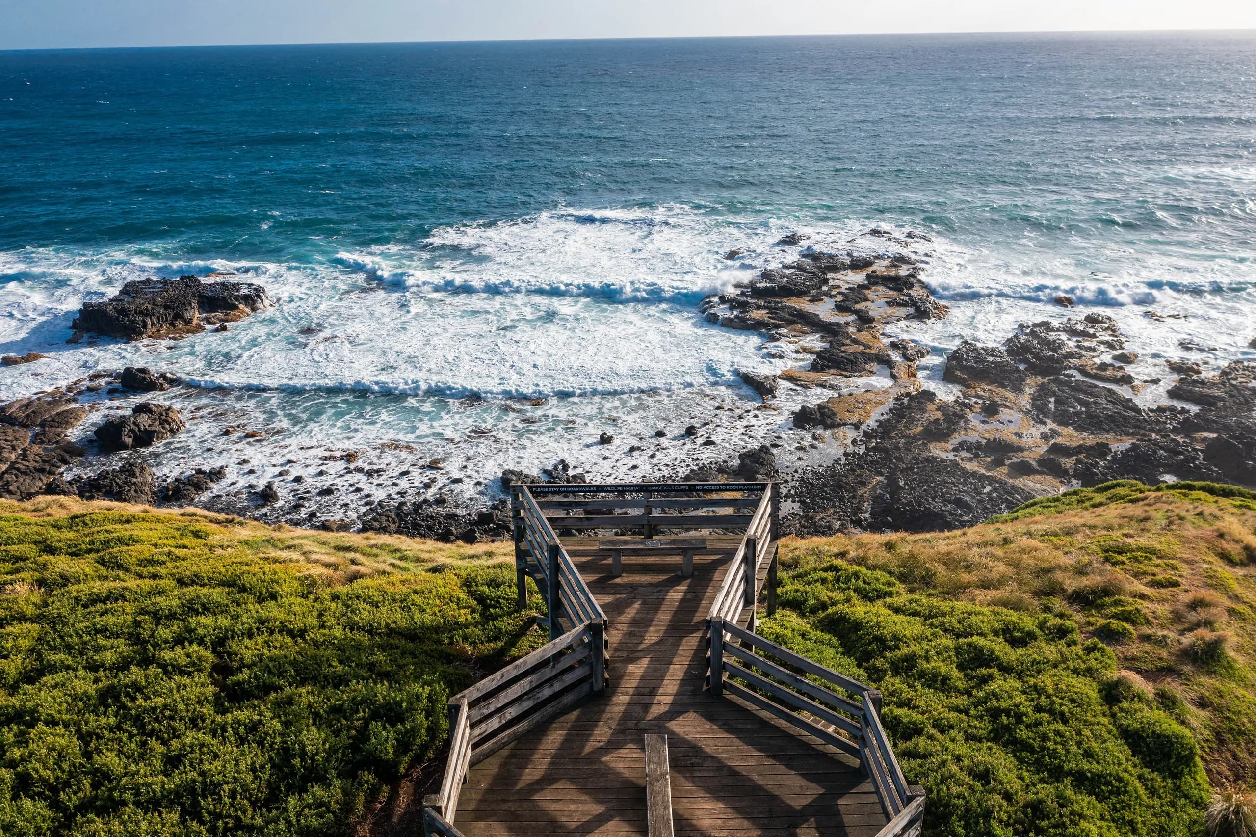 Boardwalk lookout above the rocky surf coast and coastal scrub at Phillip Island